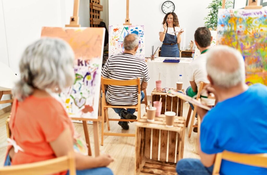 A group of seniors attend an art class provided in an assisted living community as a provided service